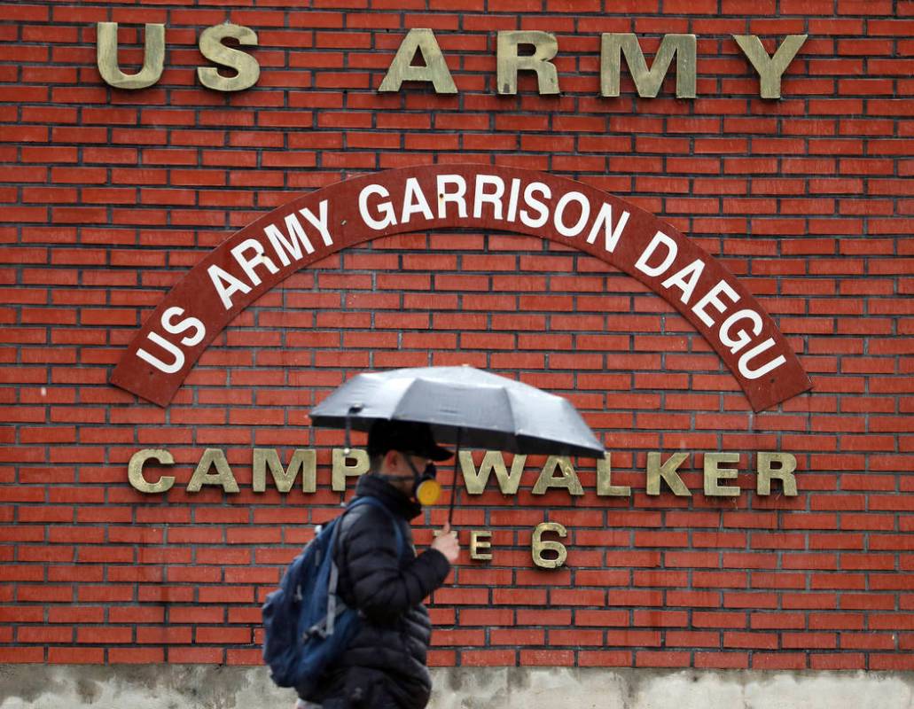 In this Tuesday, Feb. 25, 2020, photo, a man passes by U.S. Army base Camp Walker, in Daegu, So ...