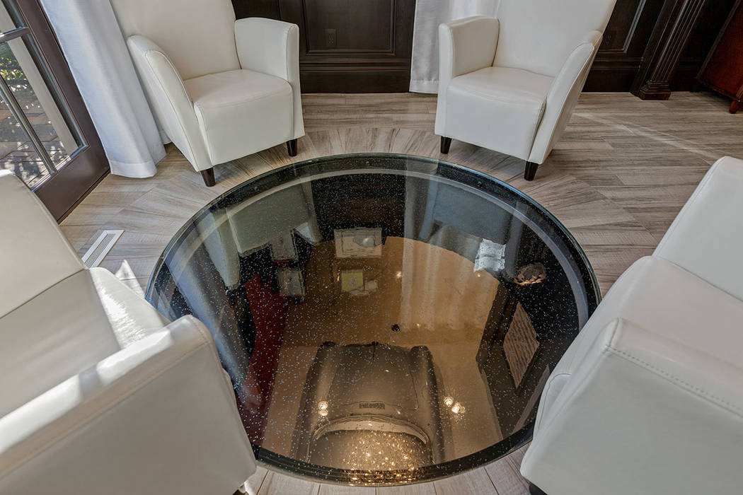 A "port hole" in the office floor offers a view of the classic cars in the garage. (Ivan Sher G ...