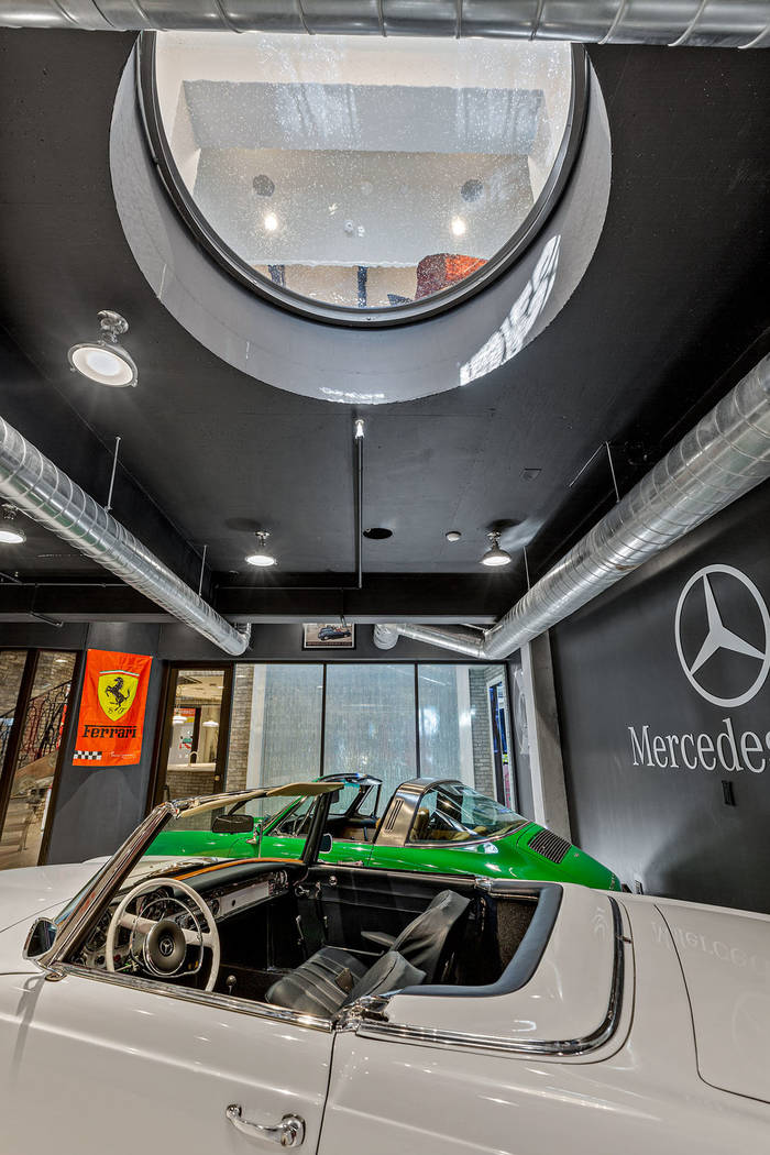 The cars are displayed in the home through "port holes" in the floor. (Ivan Sher Group)