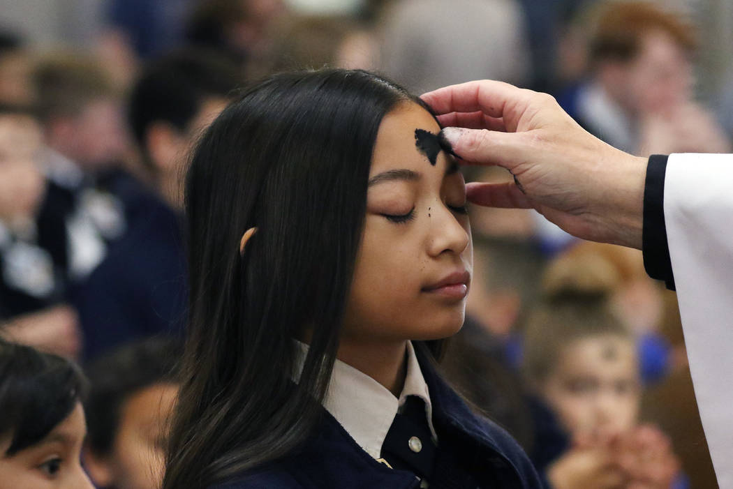 St. Viator Catholic School student Jaila Ann Dela Llana, 12, receives ashes from the Rev. Dan N ...