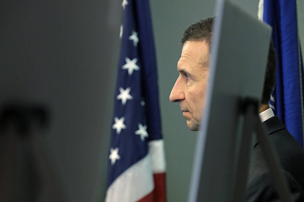 Raymond Duda, FBI Special Agent in Charge in Seattle, stands next to a flag and display boards ...