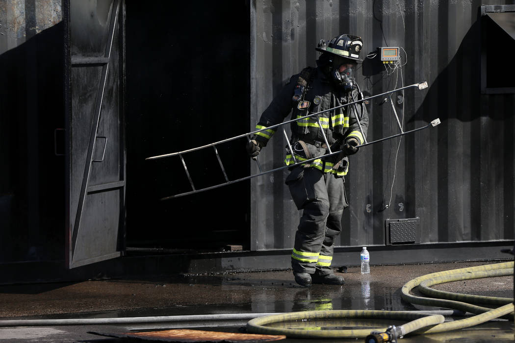 North Las Vegas firefighter paramedic Nathan Vanwingerden carries out a ladder during a multiag ...