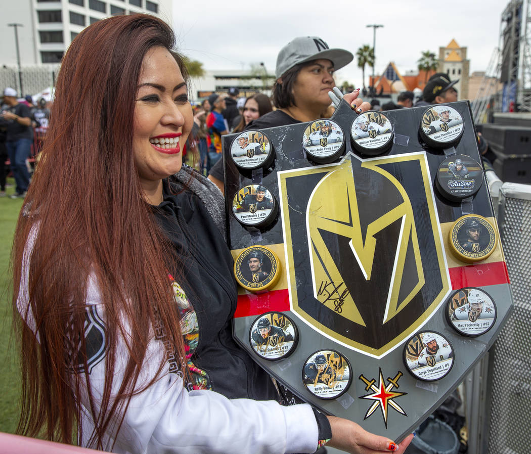 Fan Farrah Stucker shows off a display of player hockey pucks she had made during the Vegas Gol ...