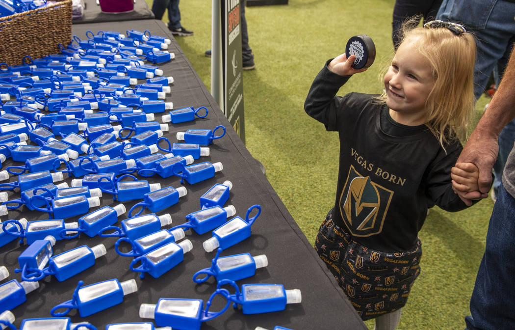 Violet Simpson, 3, shows off her hockey puck beside a table of hand sanitizer during the Vegas ...
