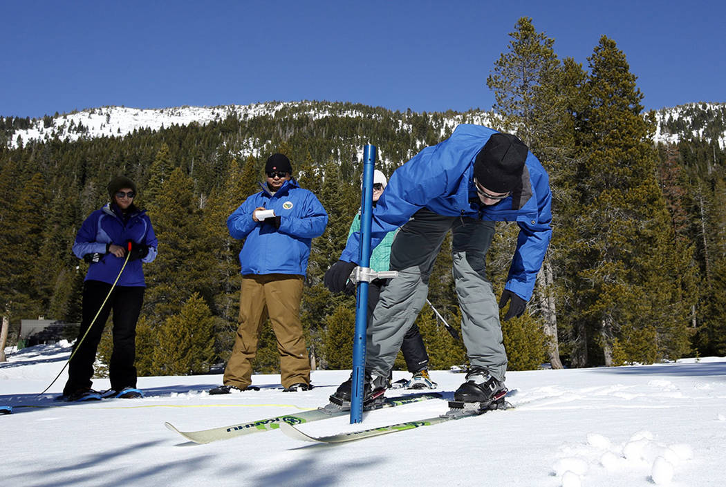 John King, right, of the Department of Water Resources, checks the snowpack depth during the se ...