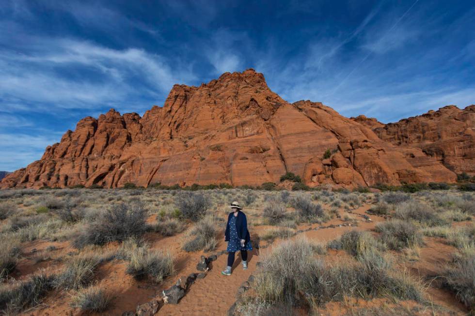 A hiker returns from Jenny’s Canyon Trail at Snow Canyon State Park near St. George, Utah, wi ...
