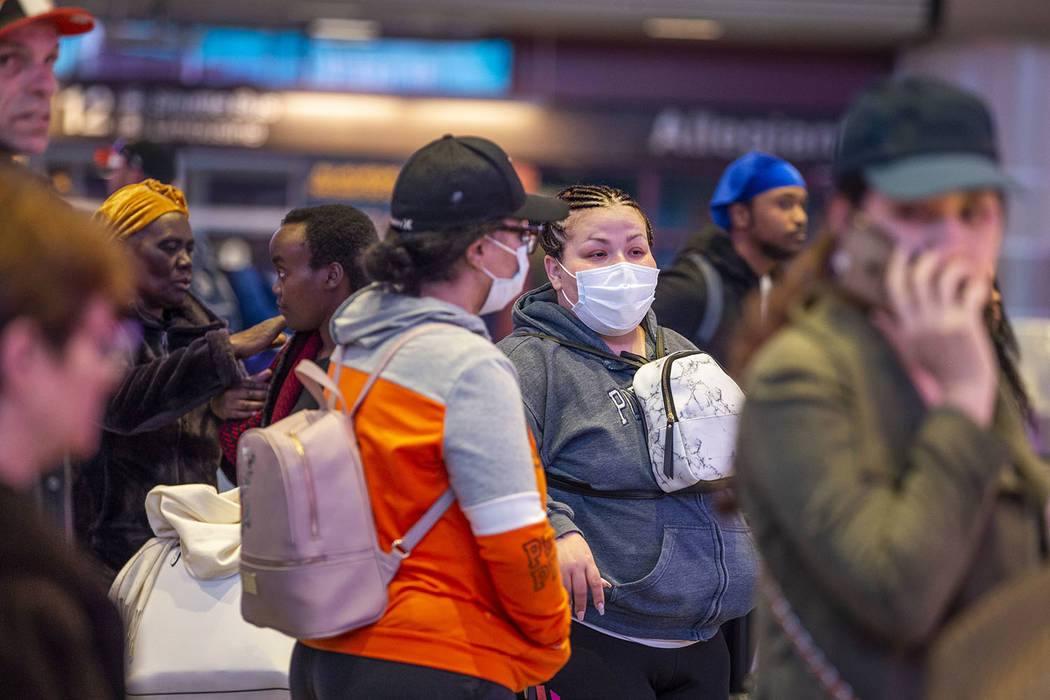 Passengers Sherry Carter, left, and Kimberly Thompson of Virginia wear face masks while awaitin ...