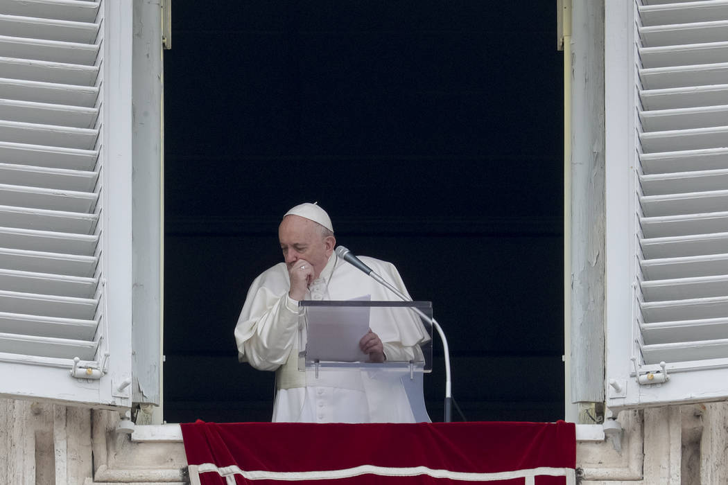Pope Francis coughs during the Angelus noon prayer he recited from the window of his studio ove ...