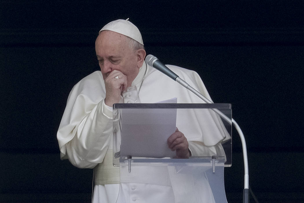 Pope Francis coughs during the Angelus noon prayer he recited from the window of his studio ove ...