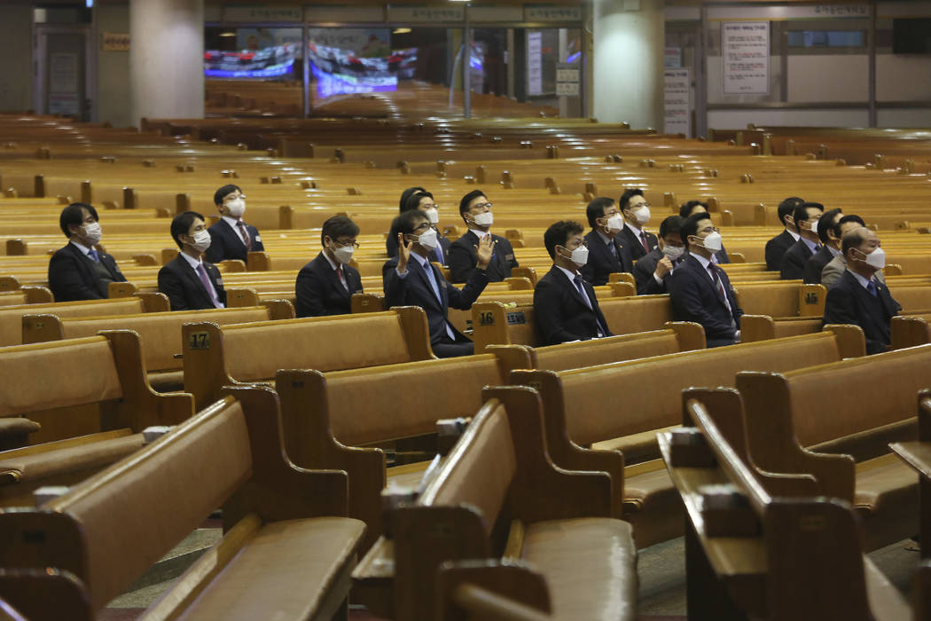 People wearing face masks attend Mass at the Yoido Full Gospel Church in Seoul, South Korea, Su ...