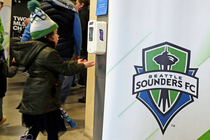 A young fan makes use of a hand-sanitizing station at CenturyLink Field prior to an MLS soccer ...