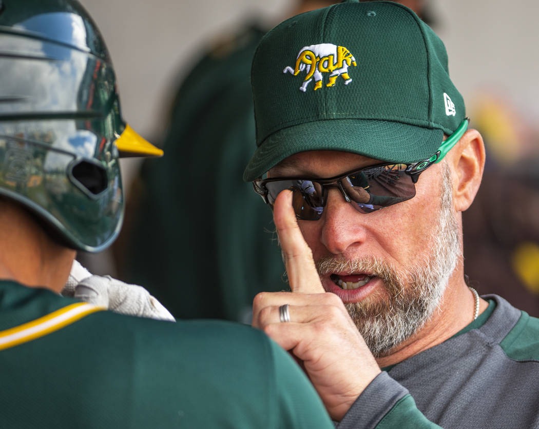 Oakland Athletics quality control coach Mark Kotsay, right, counsels a player in the dugout ver ...