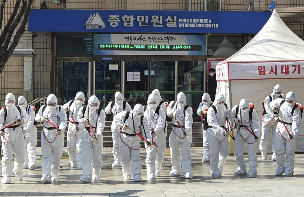 South Korean soldiers wearing protective suits spray disinfectant to prevent the spread of a ne ...