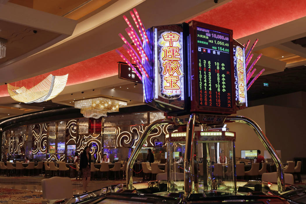 A woman walks past some gaming tables at MGM Cotai Resort in Macau Tuesday, Feb. 13, 2018. (AP ...