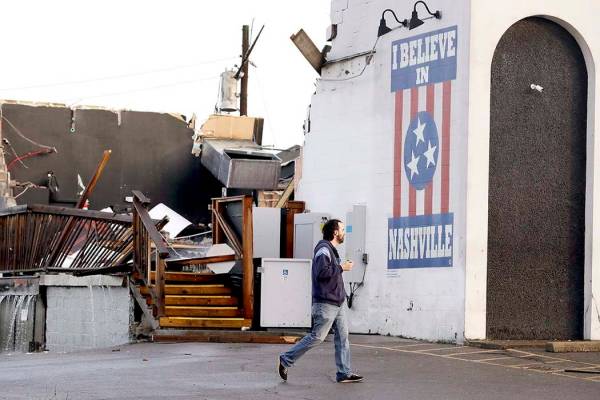 A man walks by The Basement East, a live music venue destroyed by storms Tuesday, March 3, 2020 ...