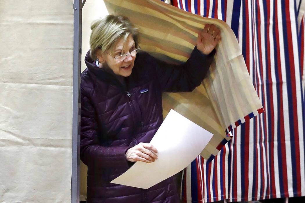 Democratic presidential candidate Sen. Elizabeth Warren, D-Mass., emerges from the booth with h ...