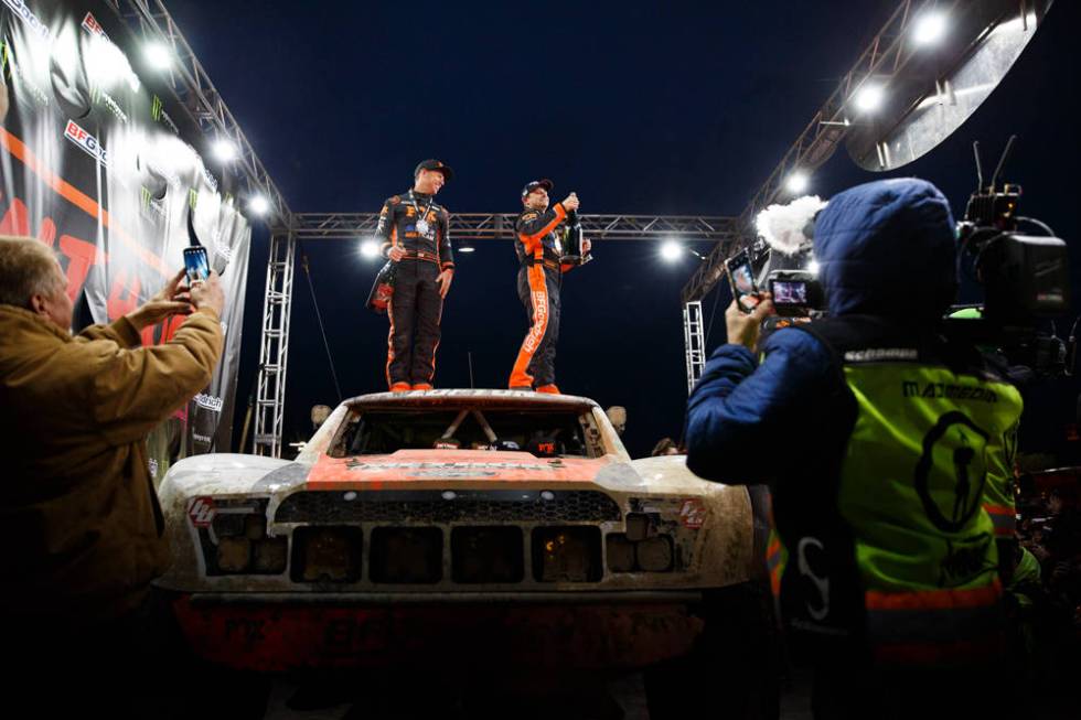 Former NASCAR racer Justin Lofton, right, gets ready to spray champagne after winning his third ...