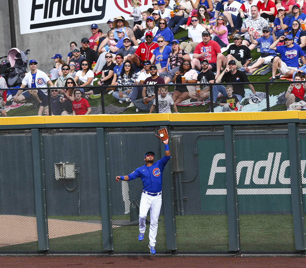 Chicago Cubs' Noel Cuevas catches a fly ball from Cincinnati Reds' Mike Moustakas, not pictured ...