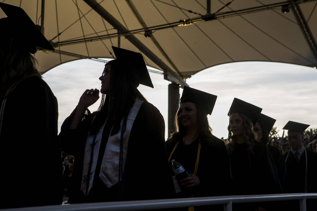Graduates make their way down the aisle to their seats at Nevada State College's commencement c ...
