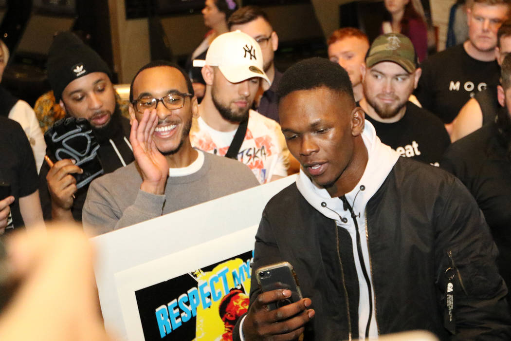 UFC middleweight champion Israel Adesanya, right, takes a selfie with Les January, left, durin ...