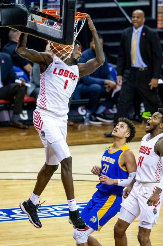 New Mexico Lobos forward Corey Manigault (1, above) dunks over San Jose State Spartans guard Ka ...