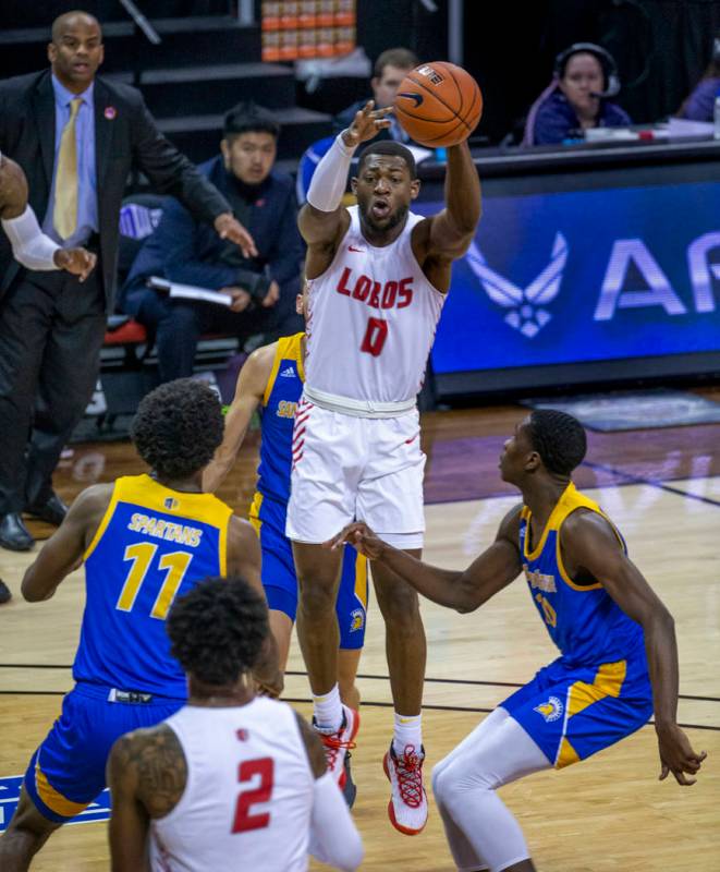 New Mexico Lobos guard Zane Martin (0, above) elevates in triple coverage to get off a pass bet ...