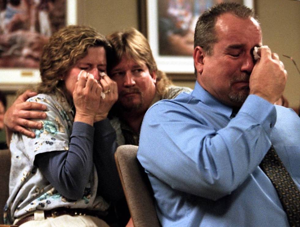 Doug Gould embraces his wife Viola and Dale Booth wipes his eyes while listening to Clark Count ...