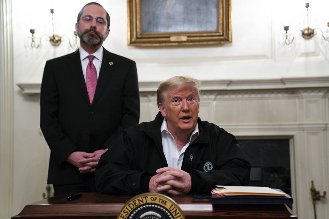 Secretary of Health and Human Services Alex Azar listens as President Donald Trump talks to rep ...