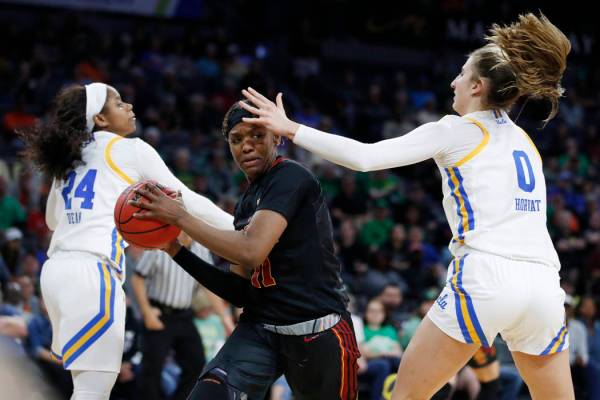 Southern California's Aliyah Jeune (11) passes around UCLA's Chantel Horvat (0) during the seco ...