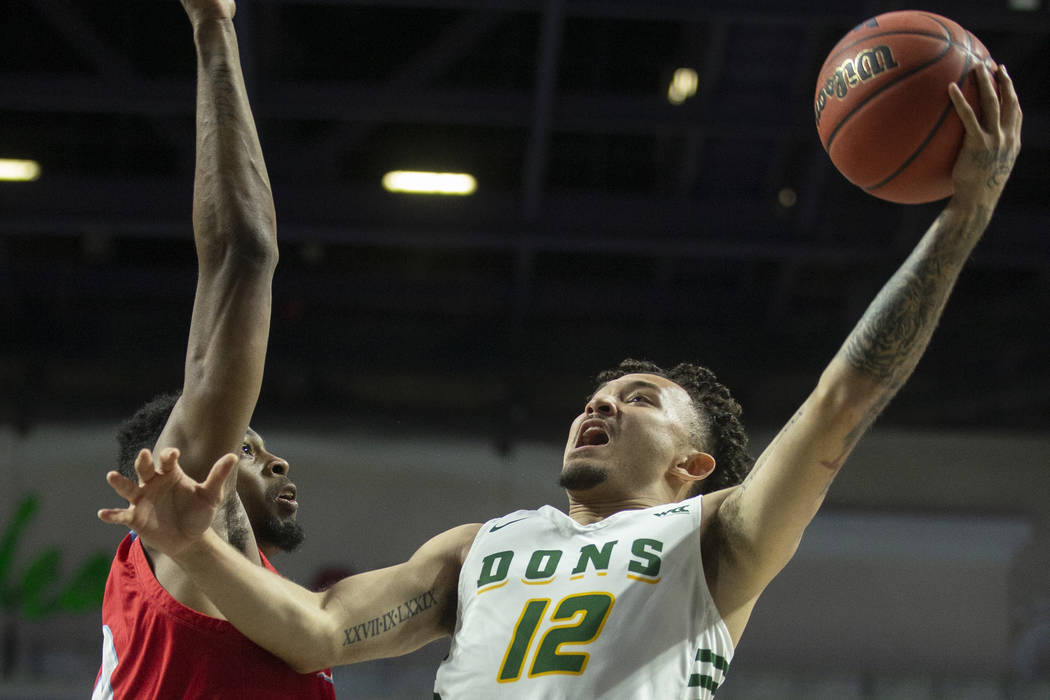 San Francisco Dons guard Trevante Anderson (12) drives past Loyola Marymount Lions forward Park ...