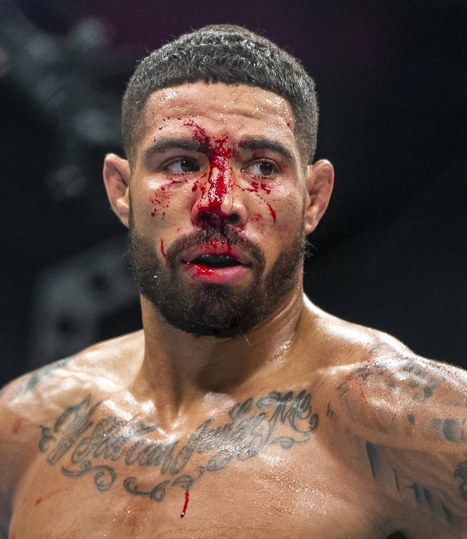 Welterweight Max Griffin is bloodied as he battles Alex Oliveira during the second round their ...