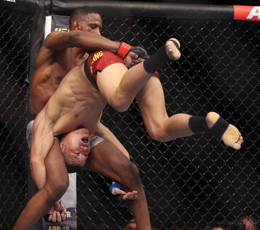 Welterweight Neil Magny, left, attempts to lift up Li Jingliang during the second round of thei ...