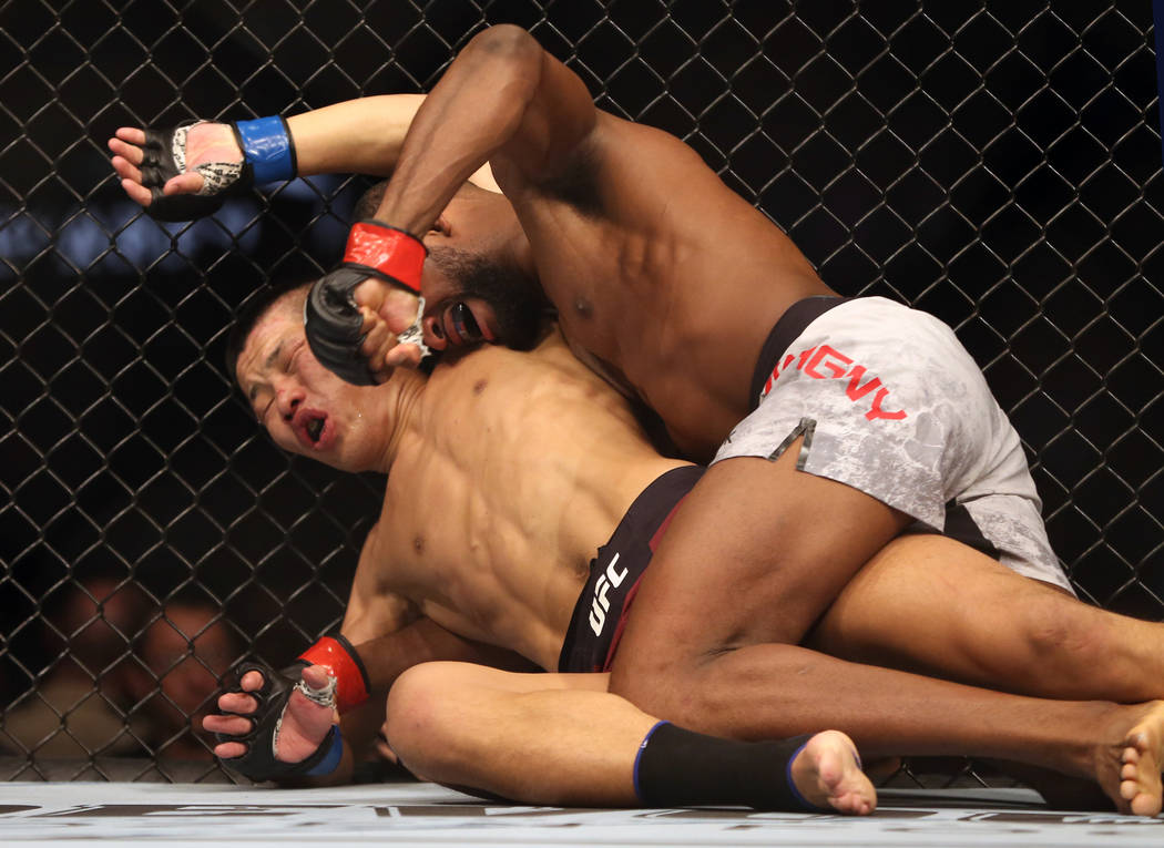 Welterweight Li Jingliang, left, is punched in the face by Neil Magny during the third round of ...