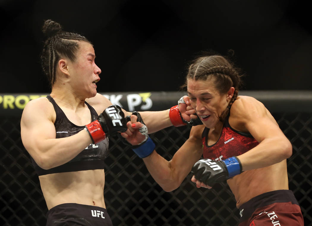 WomenÕs Strawweight Weili Zhang, left, connects on a punch on Joanna Jedrzejczyk during th ...