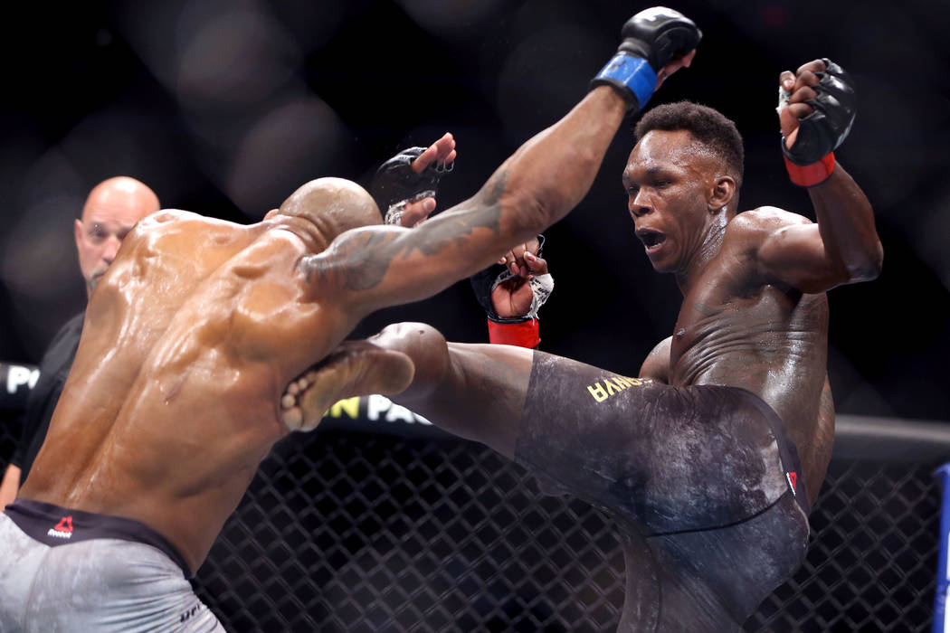 Middleweight Yoel Romero, left, is kicked by Israel Adesanya during the second round of their U ...