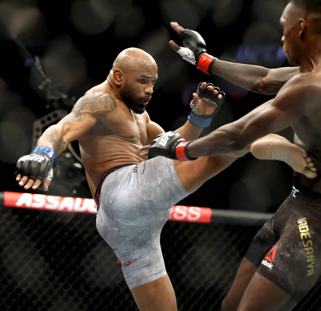 Middleweight Yoel Romero, left, sends a kick to the stomach of Israel Adesanya during the secon ...