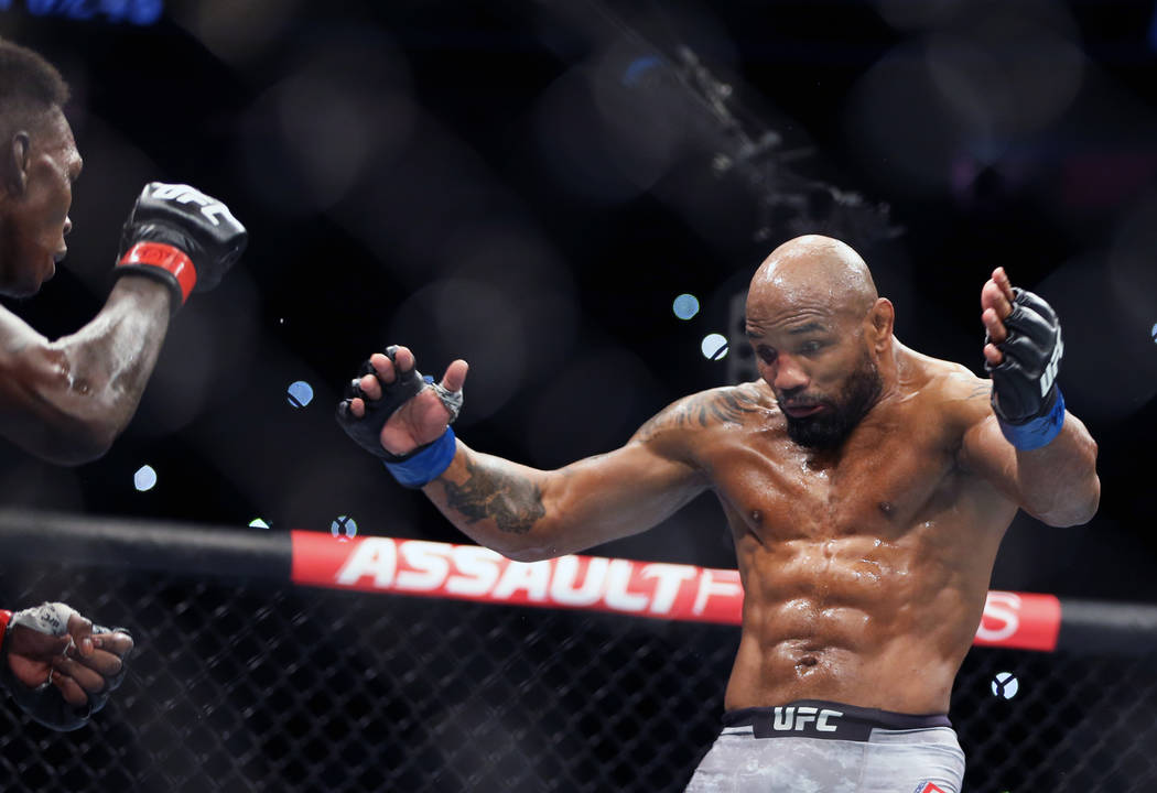 Middleweight Israel Adesanya, left, looks to Yoel Romero who attempts to draw him in during the ...