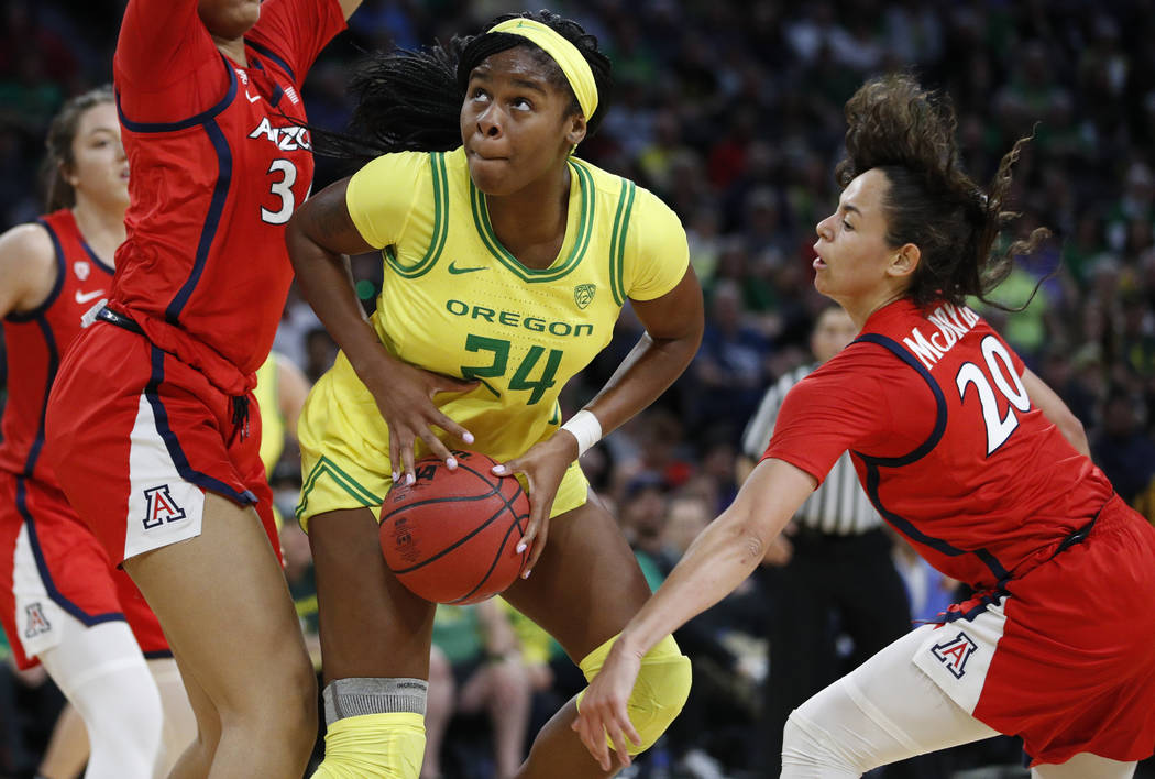 Oregon's Ruthy Hebard (24) drives around Arizona's Dominique McBryde (20) during the second hal ...