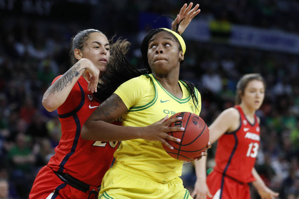 Oregon's Ruthy Hebard (24) drives into Arizona's Dominique McBryde (20) during the second half ...