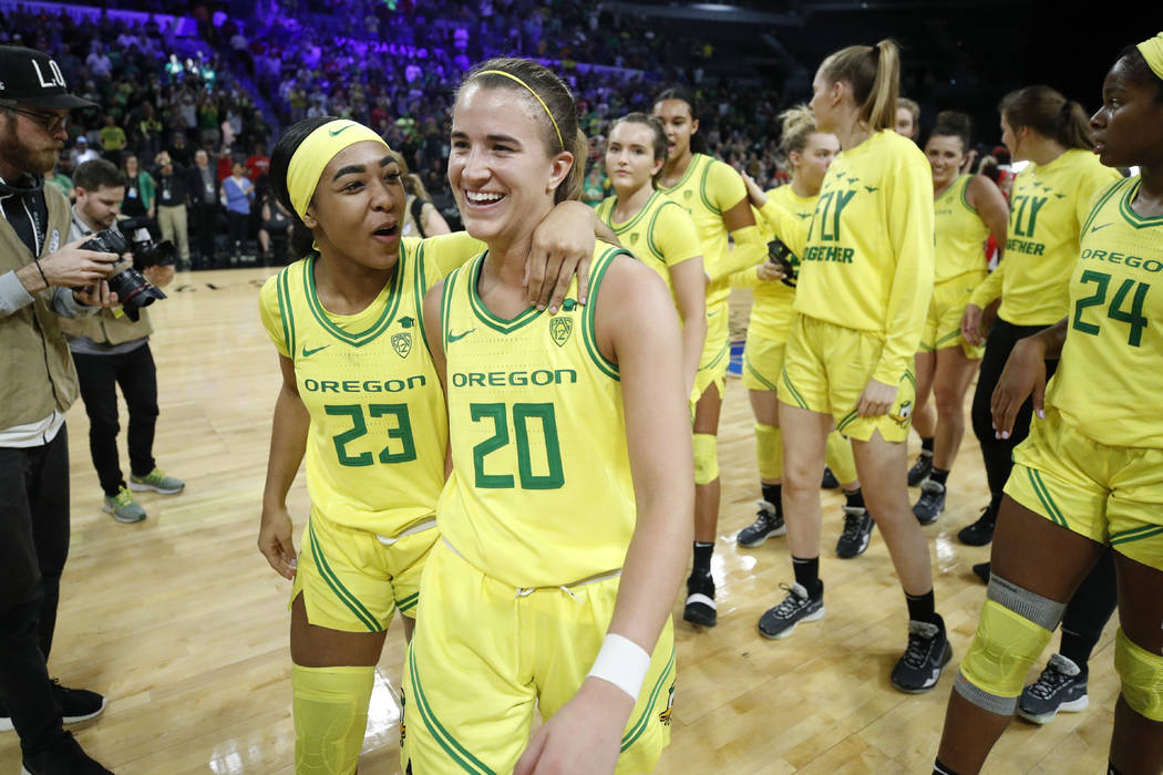 Oregon's Minyon Moore (23) and Sabrina Ionescu (20) walk off the court after defeating Arizona ...