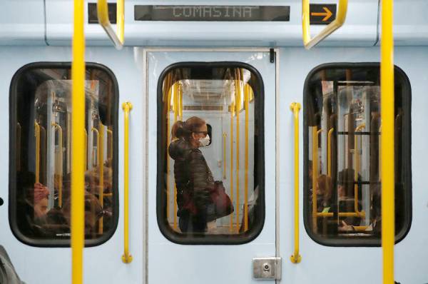 A woman wearing a face mask stands in a subway train in Milan, Italy, on March 5, 2020. (AP Pho ...