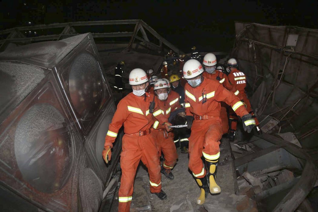 Rescuers evacuate an injured person from the rubble of a collapsed hotel building in Quanzhou c ...