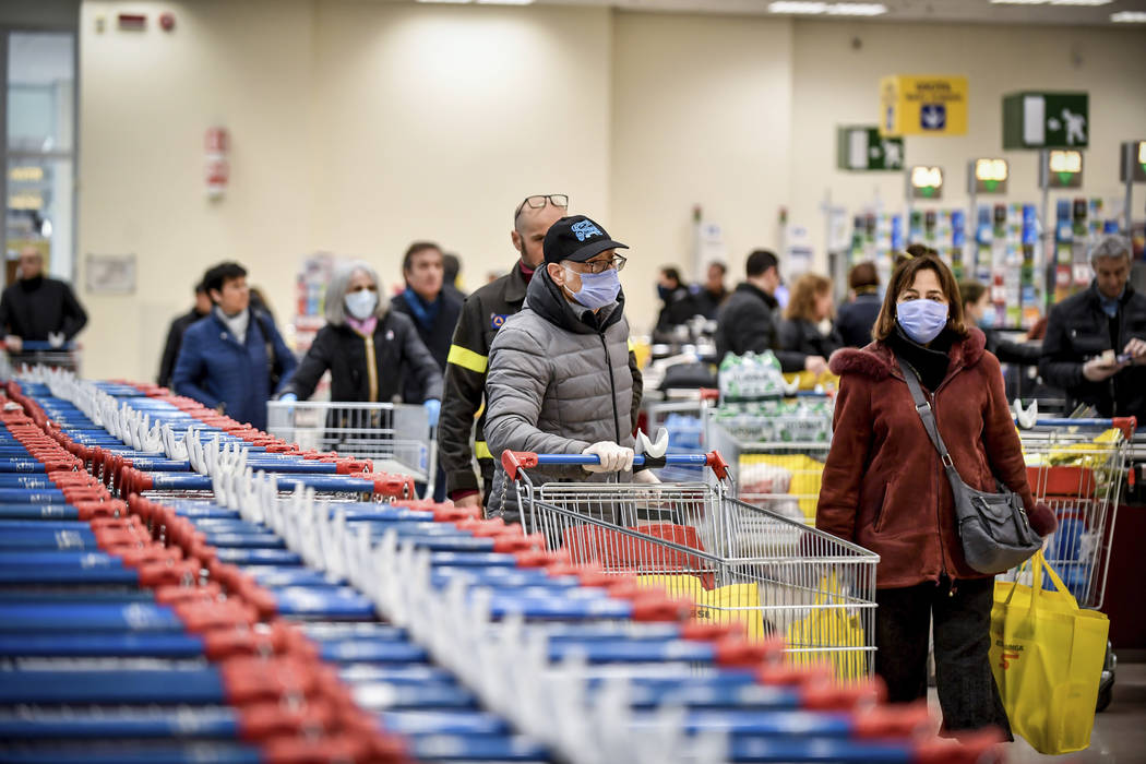 People wear masks at a supermarket in Milan, Italy, Sunday, March 8, 2020. Italy announced a sw ...