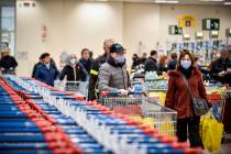 People wear masks at a supermarket in Milan, Italy, Sunday, March 8, 2020. Italy announced a sw ...