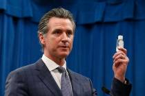California Gov. Gavin Newsom displays a bottle of hand sanitizer while saying the state would t ...