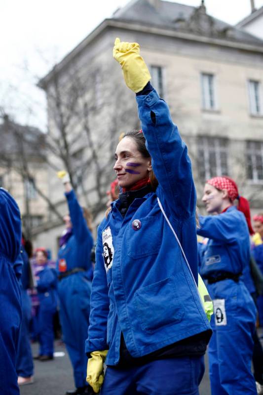 A woman raises her fist during a march as part of the International Women's Day, in Paris, Sund ...