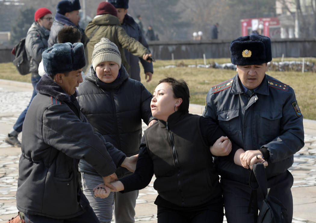 Kyrgyz policemen detain an activist of the Femen women's rights movement at Victory Square duri ...