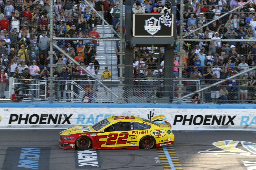 Joey Logano takes the checkered flag to win a NASCAR Cup Series auto race at Phoenix Raceway, S ...