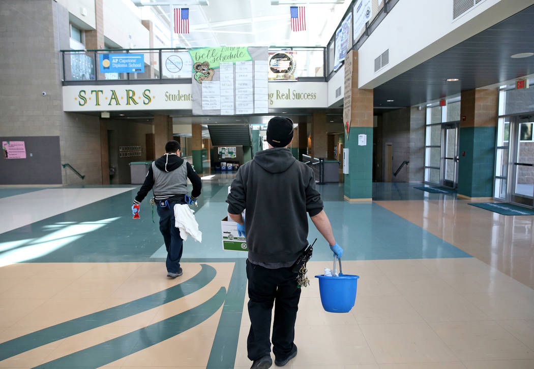 Members of the custodial team at Rancho High School in North Las Vegas prepare to disinfect sur ...
