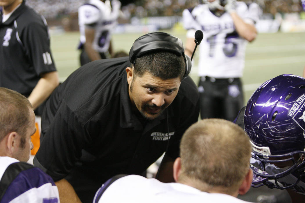 Weber State defensive line coach Chad Kauha'aha'a talks to his players as they play Hawaii in a ...